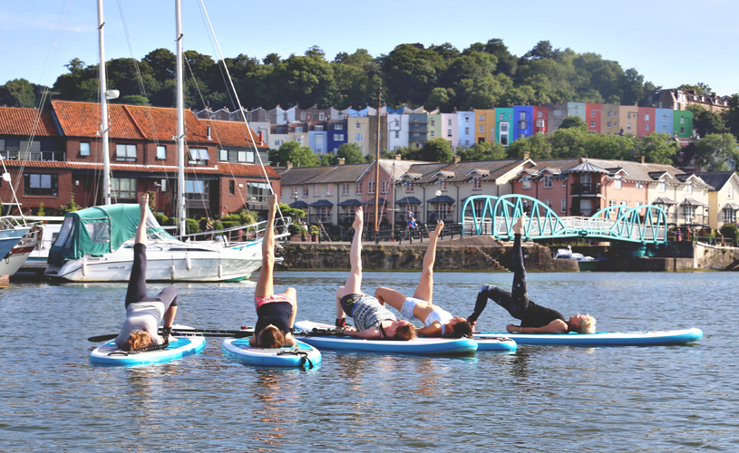People doing yoga on paddle boards on Bristol harbour